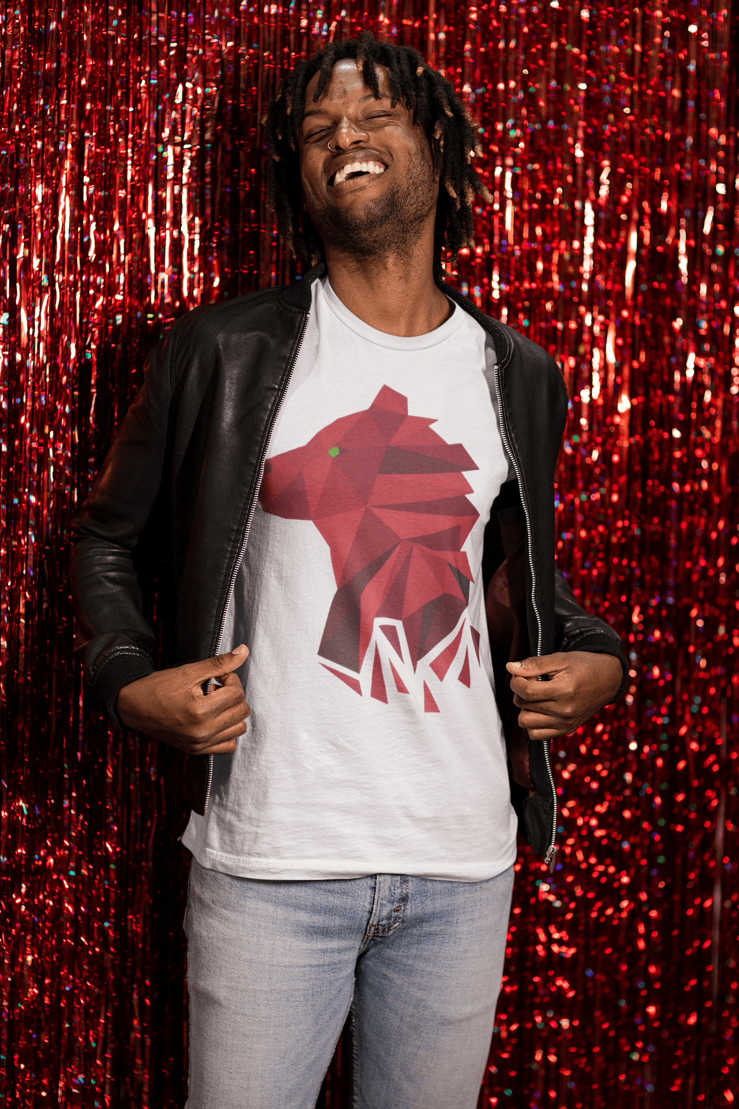 A happy man standing against a red foil fringe curtain while posing in a Bella+Canvas 3001 White Tee with our Polygonal Bear design shown front and center.