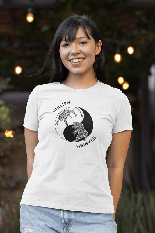 A happy woman wearing our Bullish/Bearish - Yin Yang - Tribal design on a white t-shirt with lights in the background.