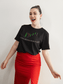 Mockup of a happy woman posing with our Black shirt of our Crazed Investor designed logo with candlestick patterns above, showing a bullish pattern.