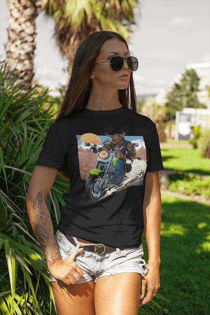 A stylish tattooed woman at a park wearing a black t-shirt with a Bull riding on a motorcycle.